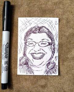 Quick ink sketch of Gila dated 1/12/2025 on a small Artist Trading Card, signed by the undersigned, with the fine-point Sharpie pen used to draw it also in frame. In the pic Gila is smiling my favorite smile in the entire world, one which I barely captured to any degree of cuteness. I forever strive to make that smile happen as often as possible.